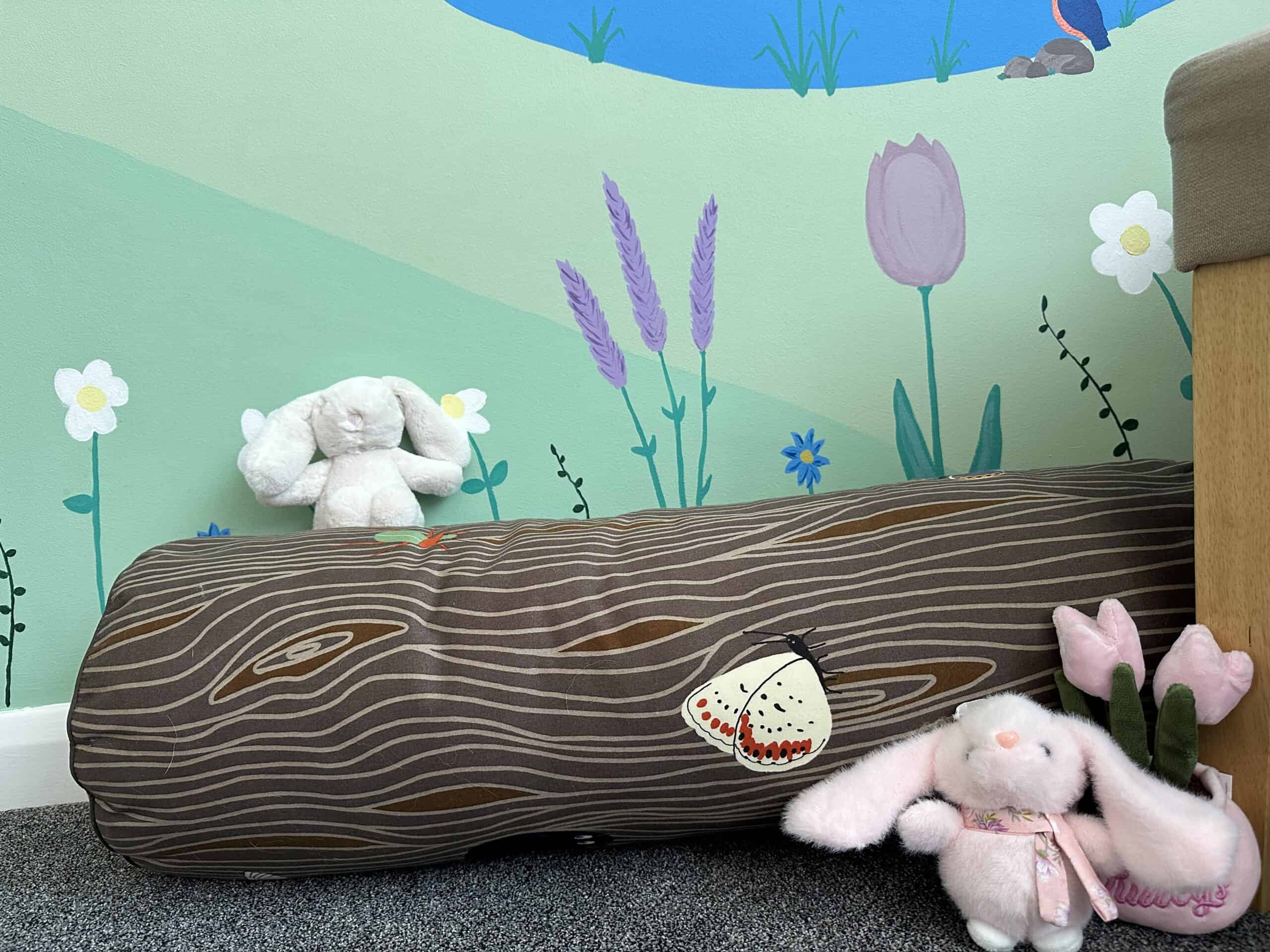 Decorative plush toys and a wooden log cushion in a colorful children's room.